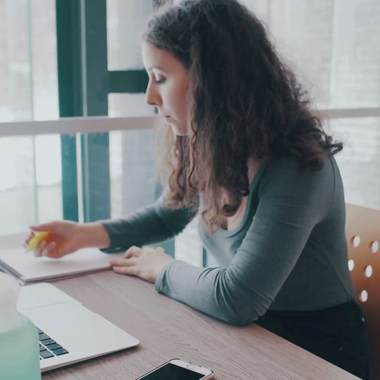 A teacher at her desk planning weekly lessons using the Teacher planner from the MyPlanova brand, highlighting sections